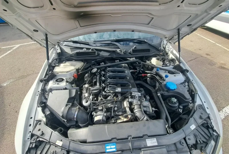 Pogled na motorni prostor bijelog BMW-a s N57D30 motorom na parkiralištu - iskustva vozača s N57 motorom