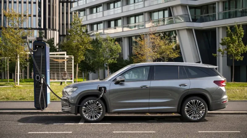 Sivi Škoda Kodiaq plug-in hibrid od 200 kW puni se na električnoj punionici u gradu