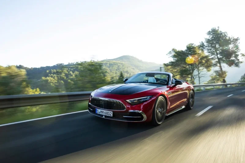 crveni maybach SL 680 vozi po cesti po suncanom vremnu kroz alpe