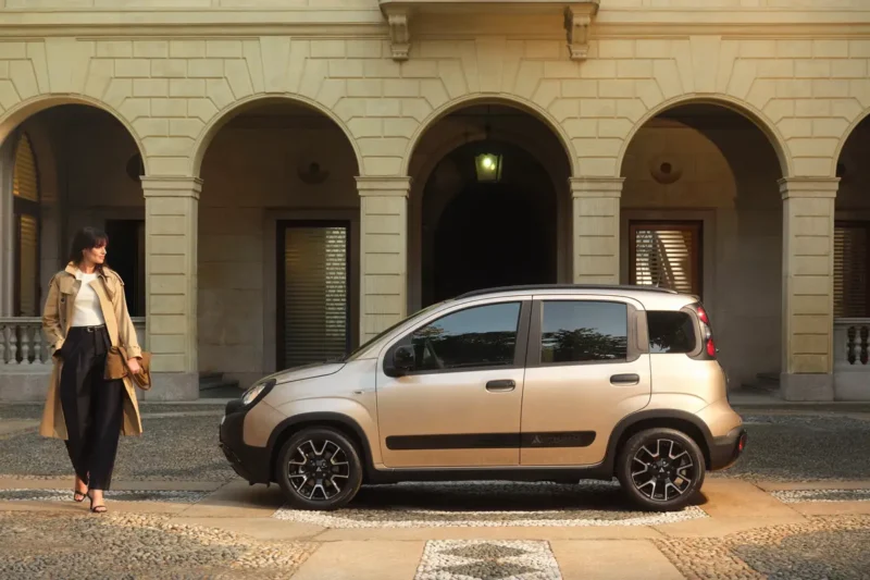 bocni prikaz fiat pandina fotografiran ispred dvorca i zena gleda novi auto