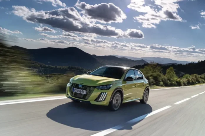 peugeot 208 vozi po ravnoj cesti kroz francusku po suncanom vremenu