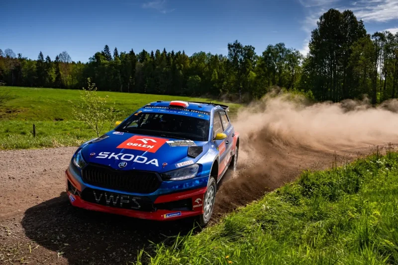 plava skoda fabia rally2 vozi bocno po makadamskoj cesti dok se iza dize oblak prasine