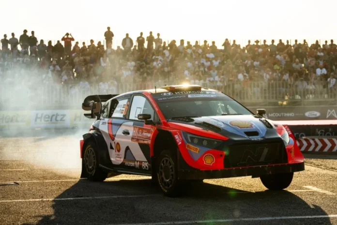 hyundai i20 wrc na reliju vozac dani sordo u pozadini se vidi puno publike dok se prasi iza auta
